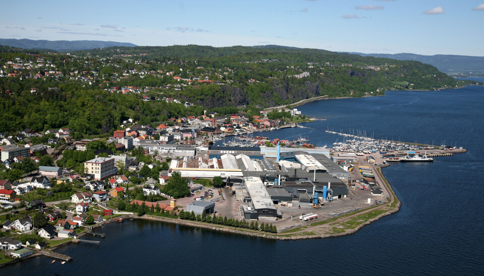 Rett utenfor gjerdet til Speira er det eneboliger, rekkehus, blokker, barnehage, flyktningmottak og selve bysentrum i Holmestrand.